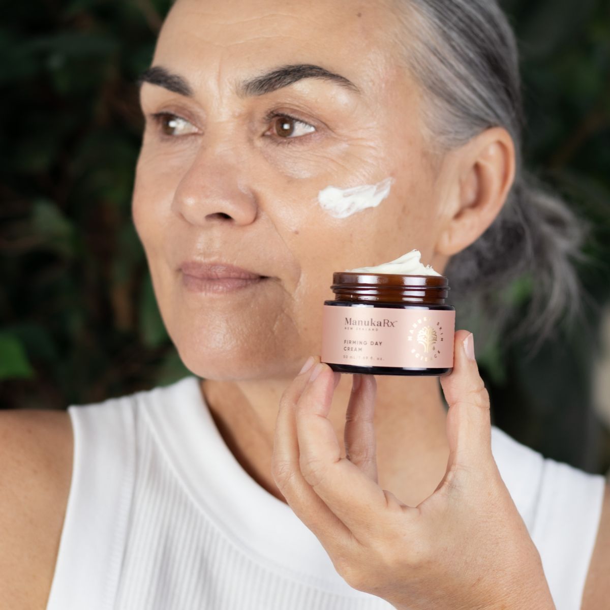 Woman applying ManukaRx Firming Day Cream to her face